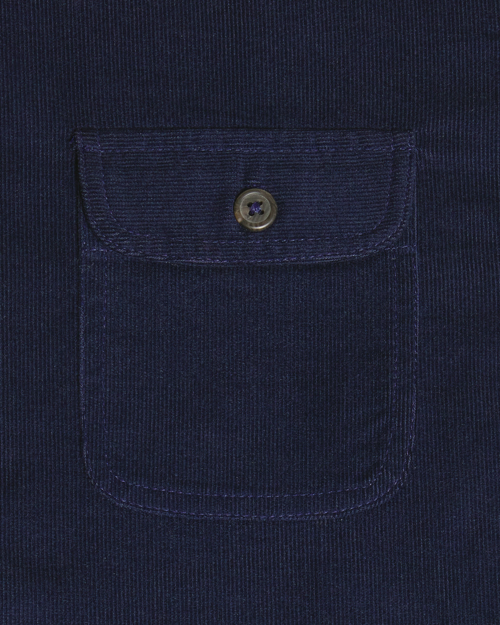 Close-up of a dark navy corduroy pocket with a buttoned flap on a matching navy corduroy garment. Color: Maritime Blue