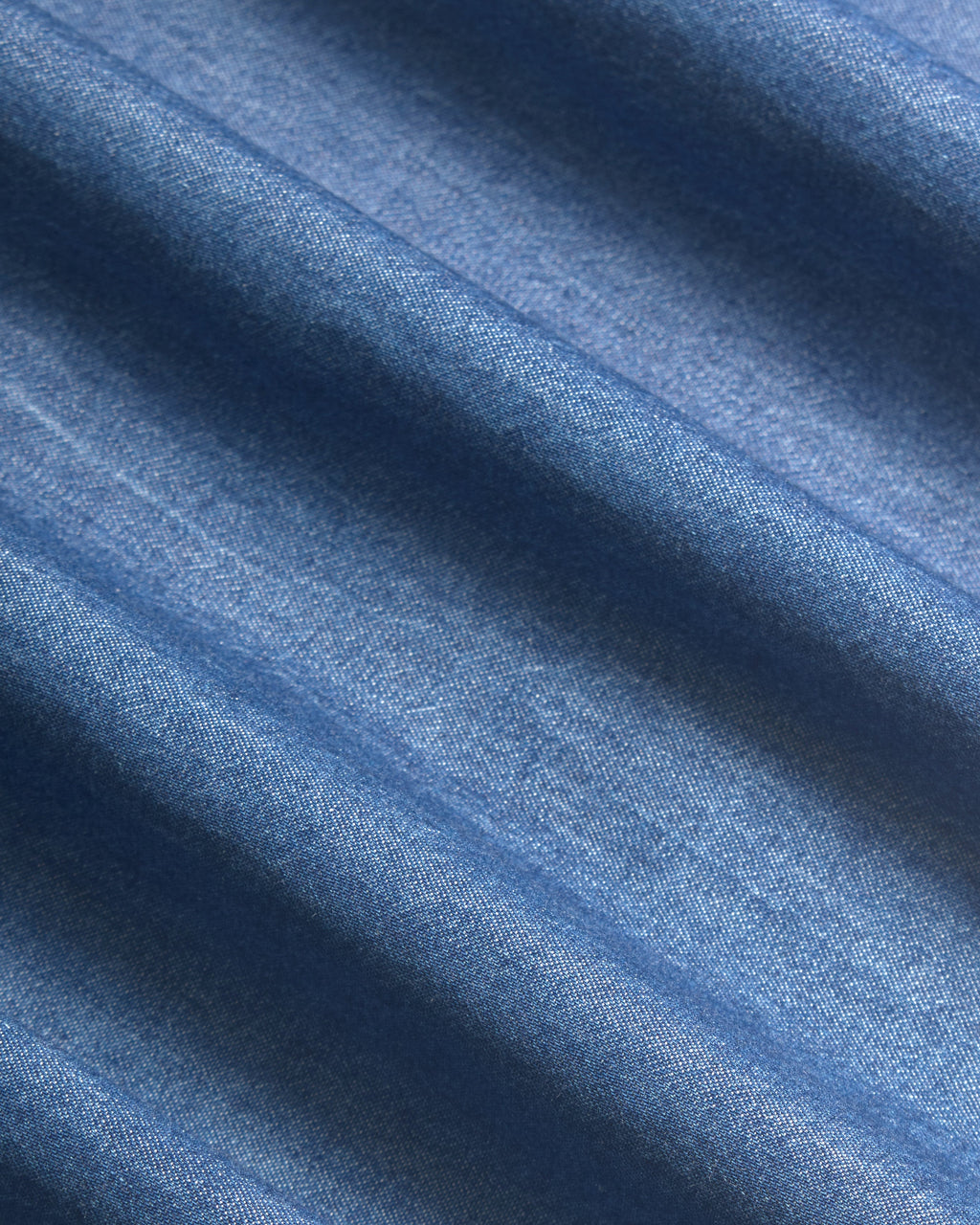 Close up of soft gentle denim folds. Color: Medium Wash Denim