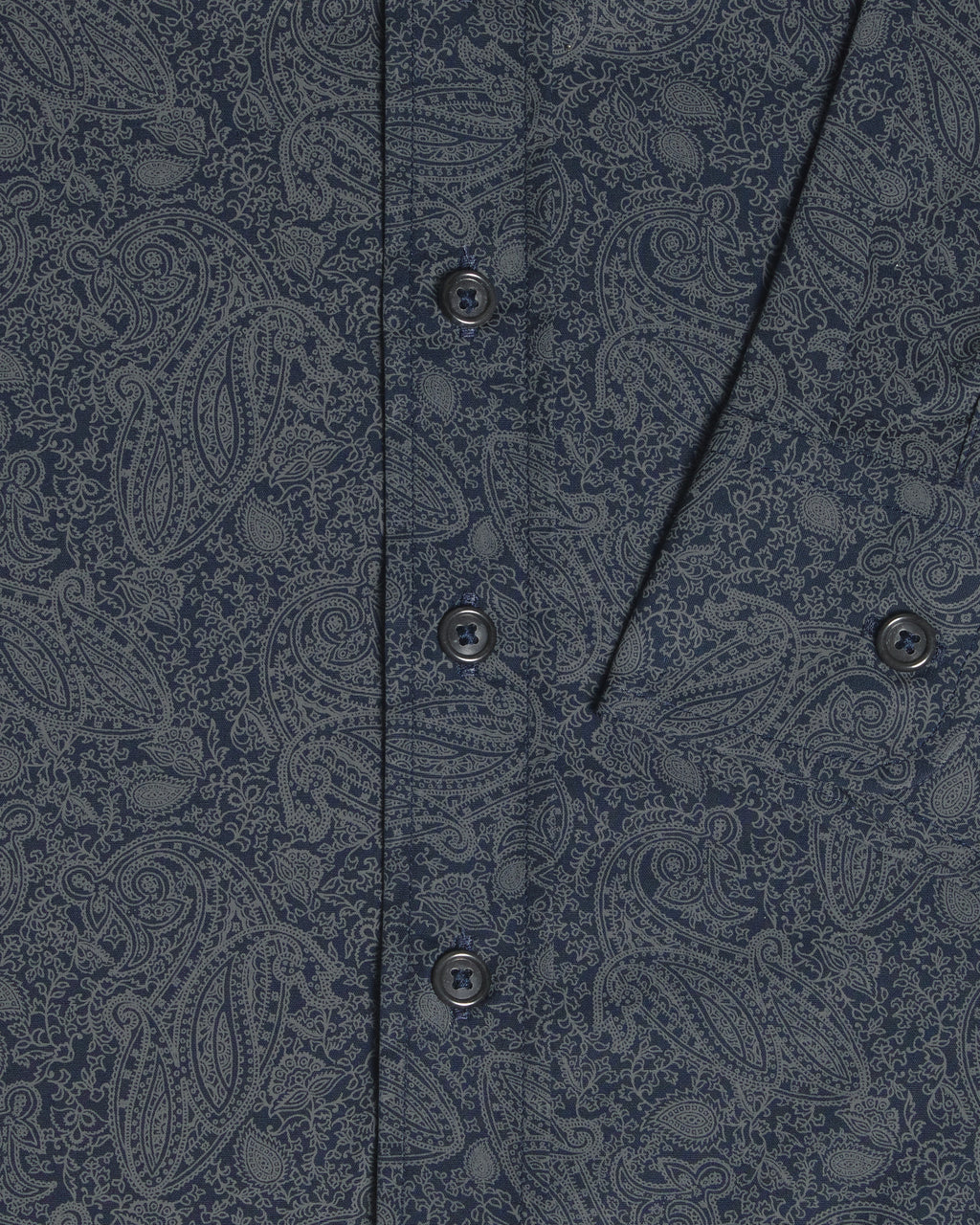 Close-up of a navy blue button-down shirt with a detailed gray paisley pattern, featuring a vertical button placket. Color: Midnight Paisley