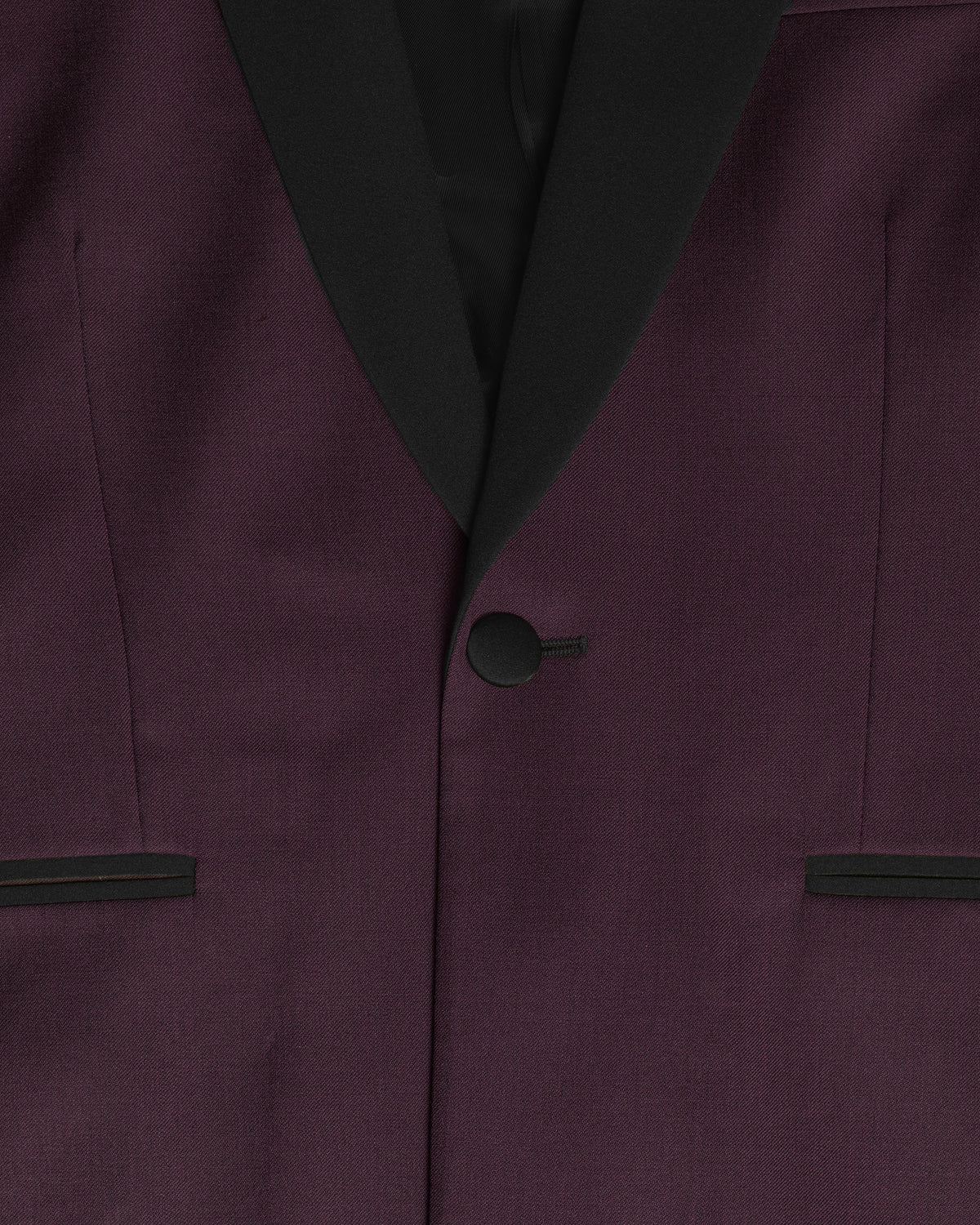 Close-up of a dark plum purple suit jacket with black satin shawl collar, a single black button, and matching black trim on the pocket flaps. Color: Deep Oxblood