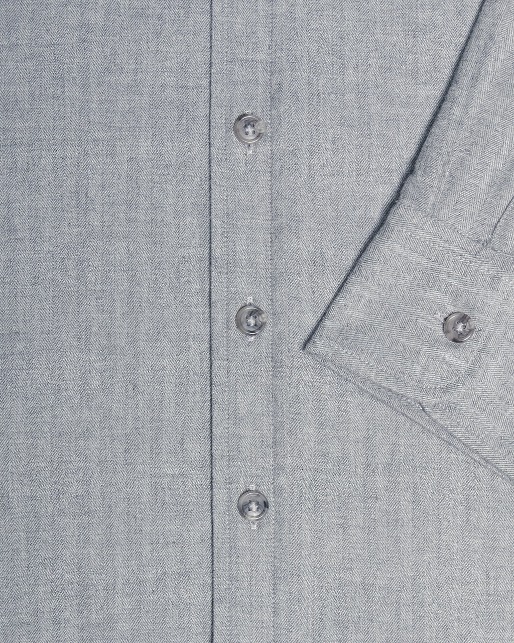 Close-up of a light gray textured button-down shirt showing the button placket and a folded cuff with a button. Color: Pewter Herringbone