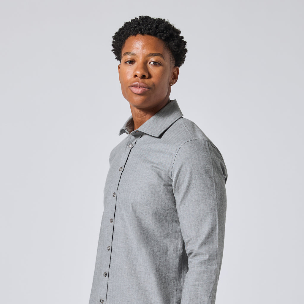 Model wearing a light gray long-sleeve button-down shirt, shown from a side profile against a solid light gray background. Color: Pewter Herringbone