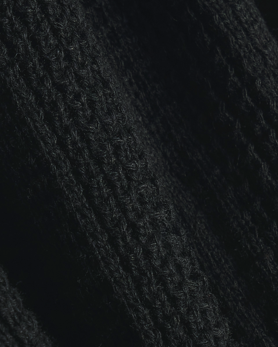Close up shot of fabric in a diagonal wave pattern. Color: Black
