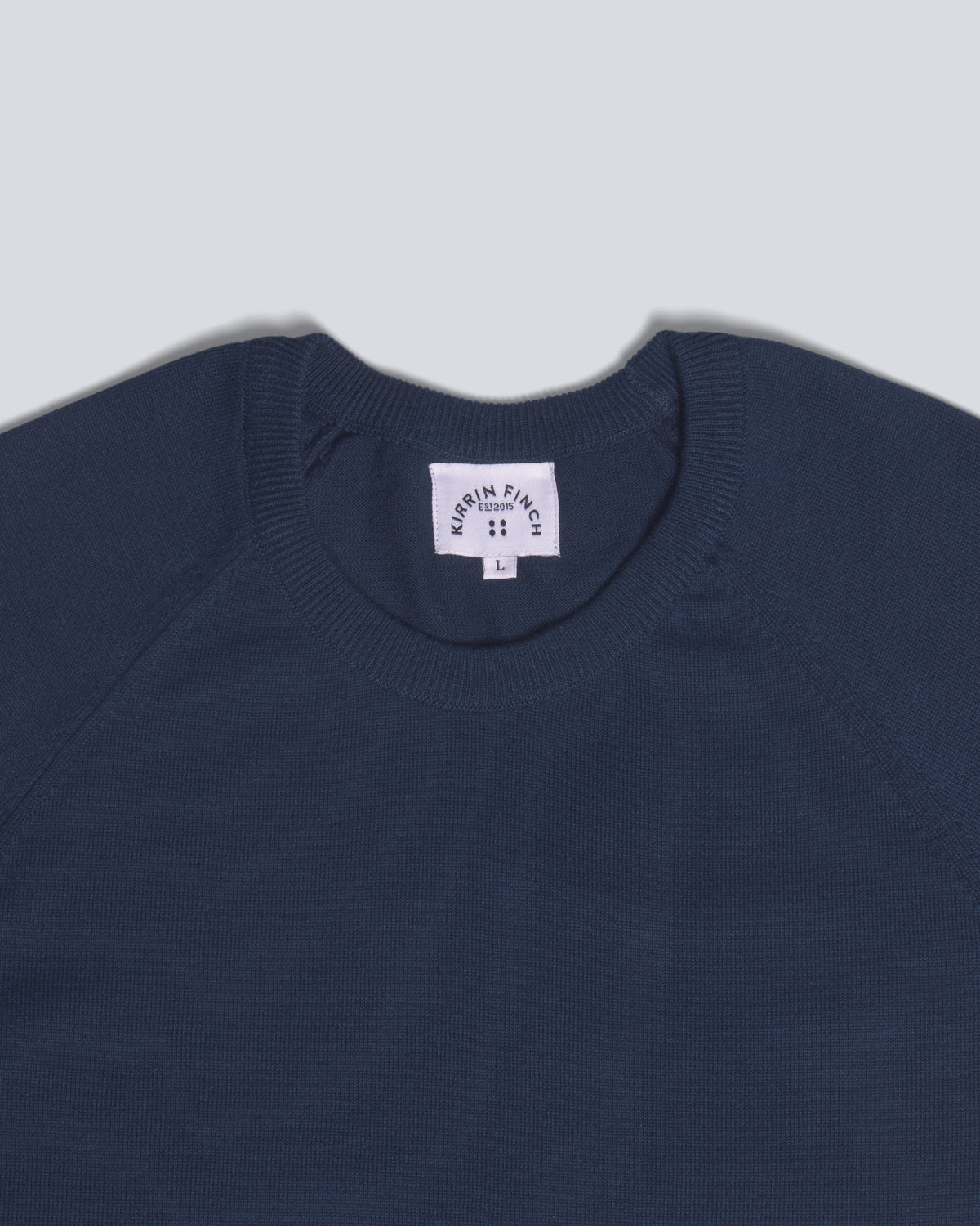 Close-up of a navy blue crewneck sweater. Color: Navy