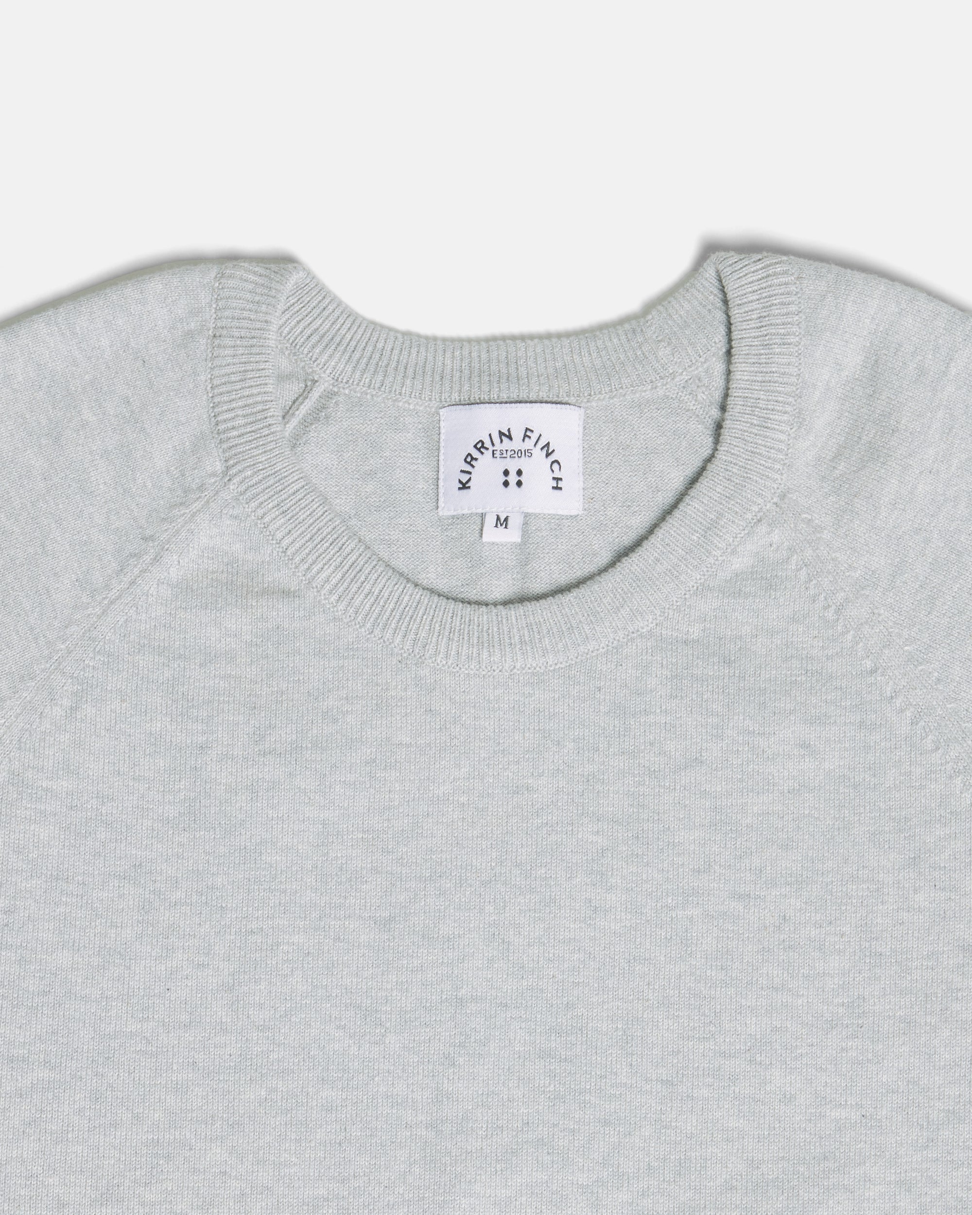 Close-up of a light gray heather crewneck sweater. Color: Heather Grey