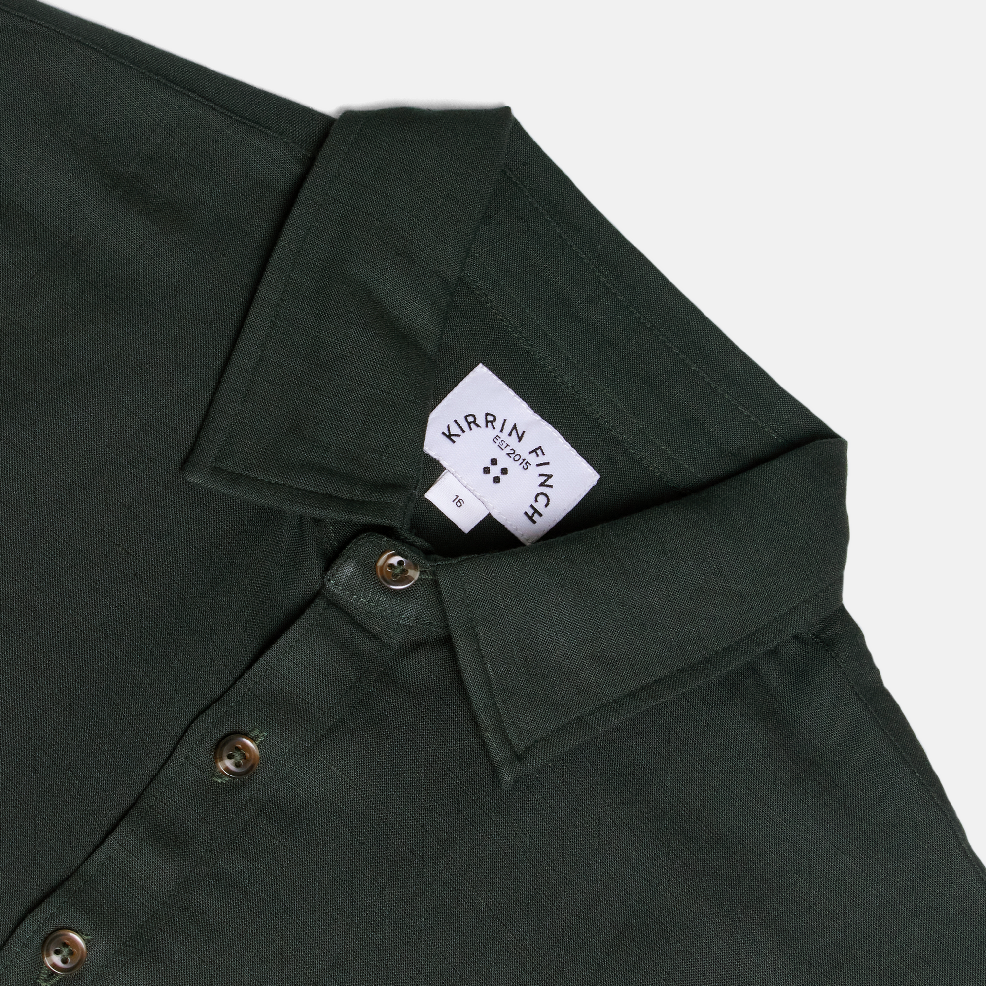Dark green shirt with Kirrin Finch logo visible. Color: Nori