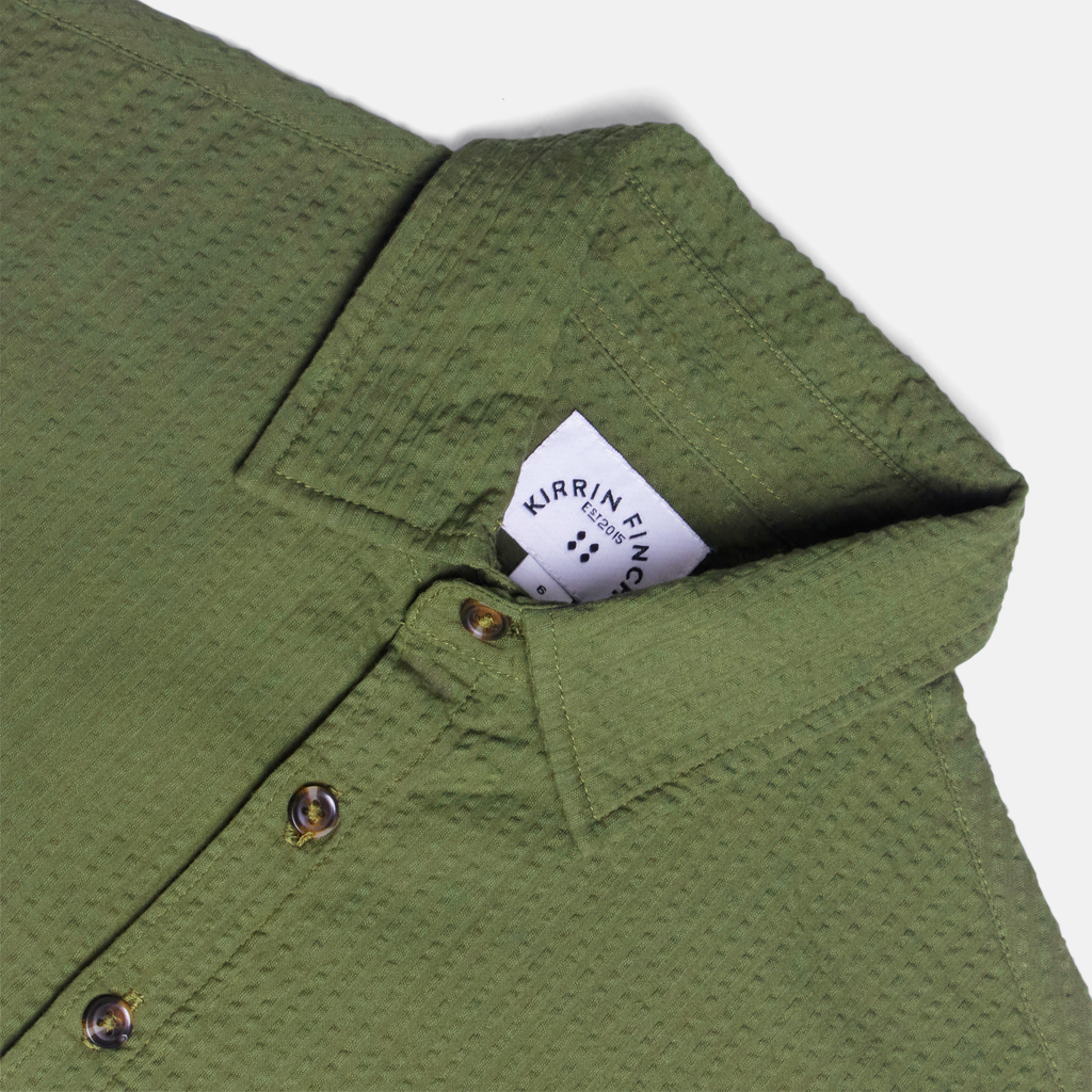 Green short sleeve shirt on a white background. Made by Kirrin Finch. Color: Nopales