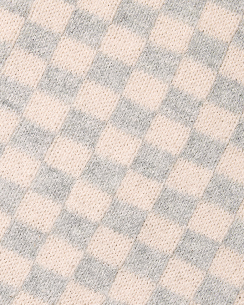 A close-up of a knit fabric with a soft checkerboard pattern in pale blush pink and light gray. Color: Saltstone Checker
