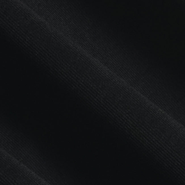 A close-up of black ribbed fabric texture with soft diagonal folds. Color: Shadow Corduroy