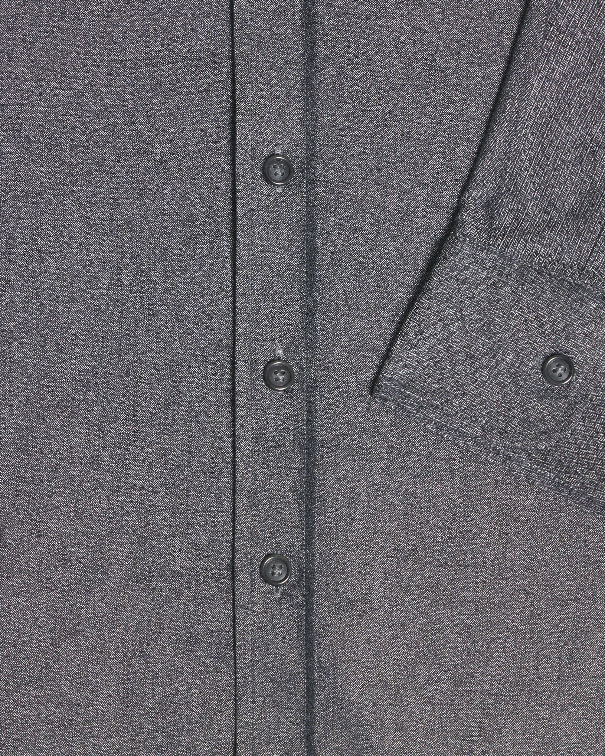 Close-up of a dark gray textured fabric garment showing the button placket and a partial chest pocket with a buttoned cuff. Color: Steel Marl Herringbone