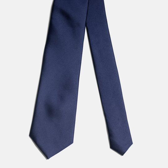 Matte navy skinny tie on light gray background