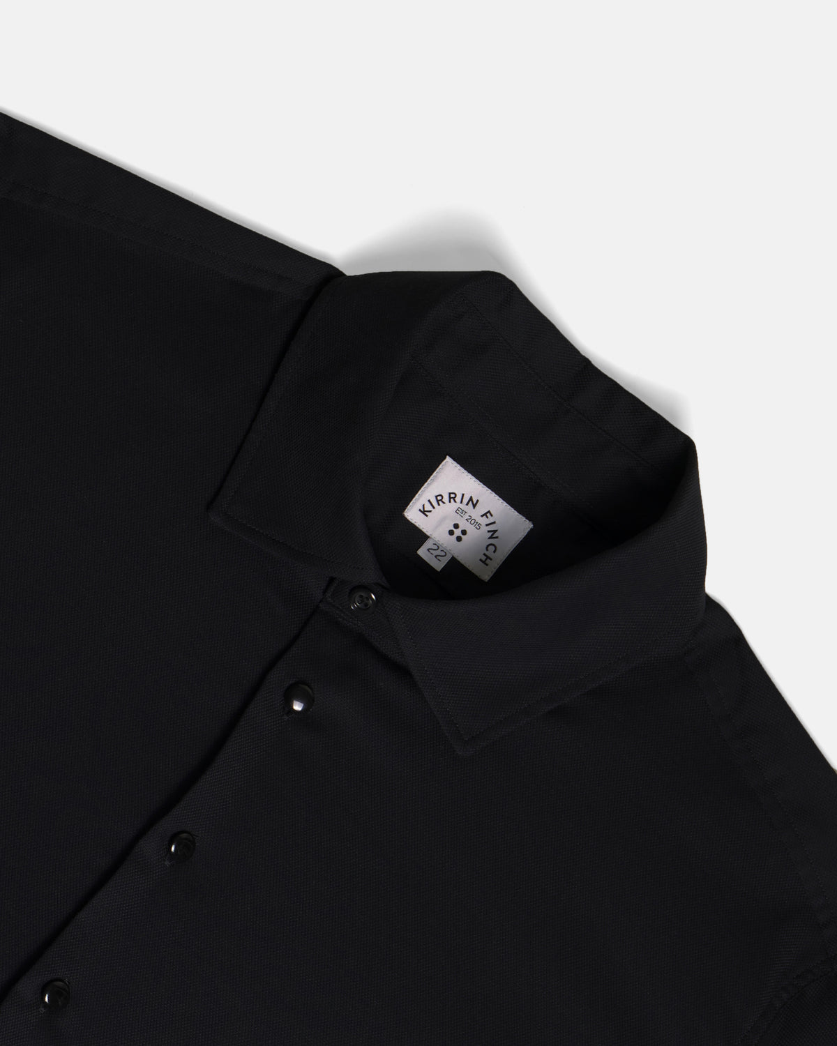 Close-up of a black collared button-up shirt. Color: Black