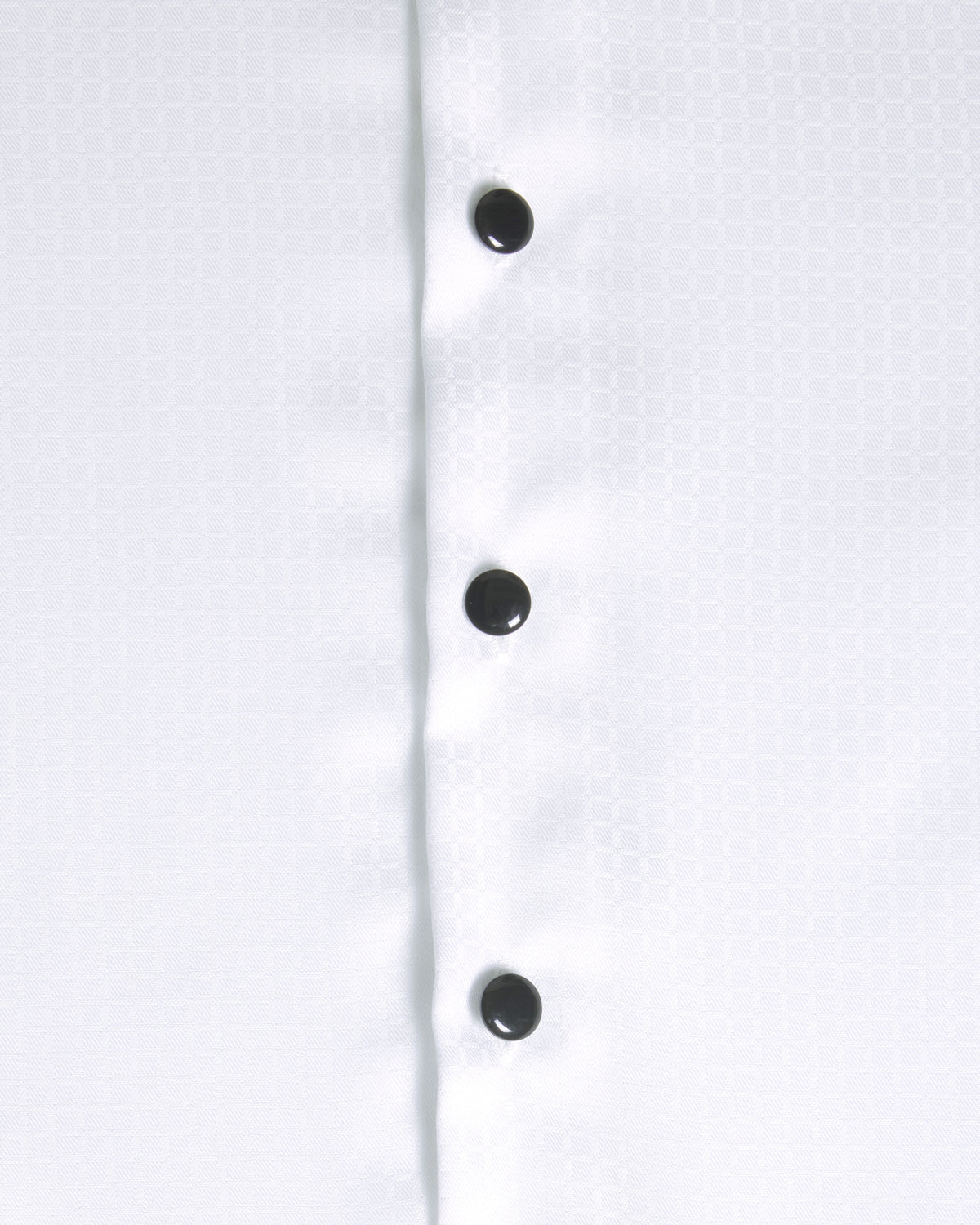 Close-up of a white button-down shirt showing the front placket with four black buttons and a subtle woven texture. Color: White Twill Grid