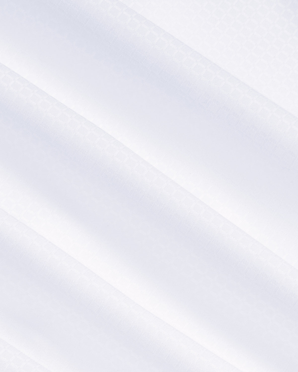 A close-up of a white fabric with a subtle, fine repeating damask pattern and soft diagonal folds. Color: White Twill Grid