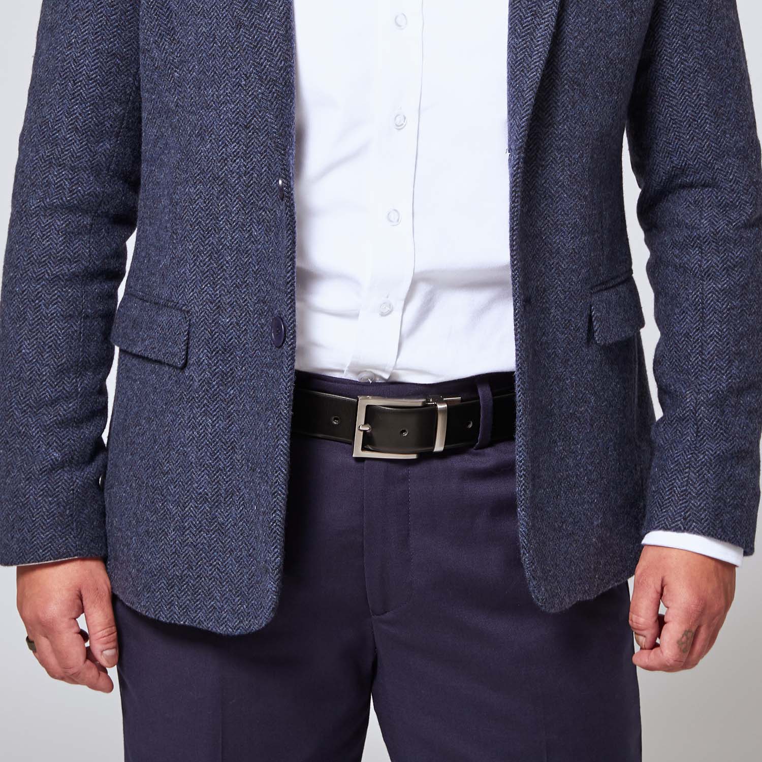 Black leather belt with zinc belt buckle on model wearing Georgie navy blue pants and navy blue tweed blazer.