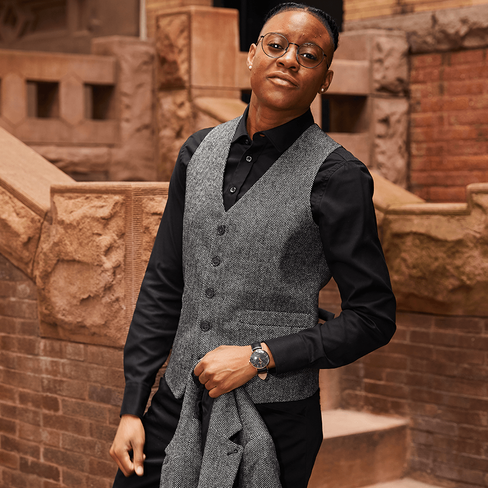 Masc woman in black dress shirt. Color: Black