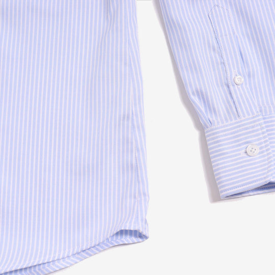 Close up shot of blue and white striped dress shirt highlighting color, pattern, and sleeve with buttons