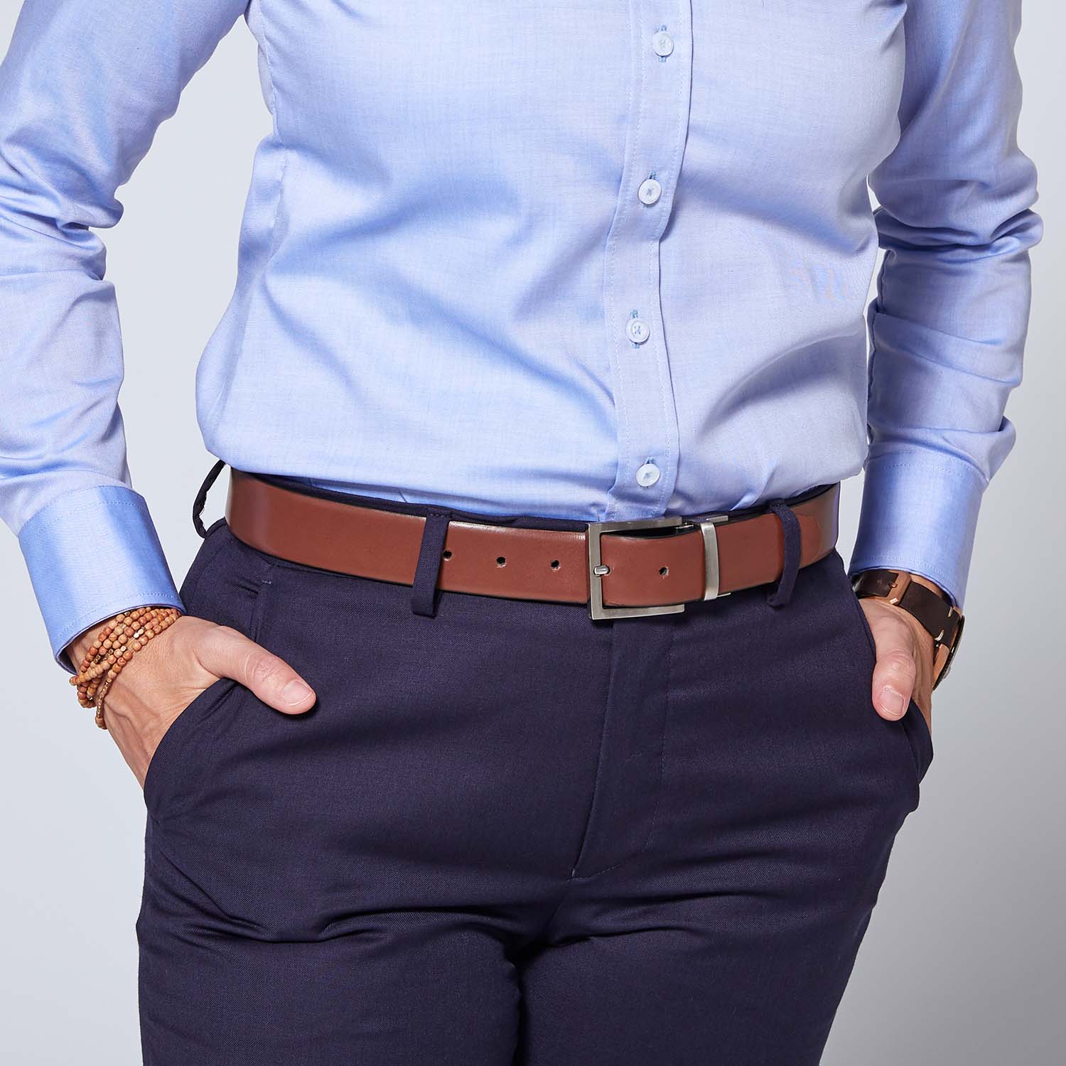 Brown leather belt on model wearing Georgie blue navy pants and blue dress shirt. All pieces by Kirrin Finch.