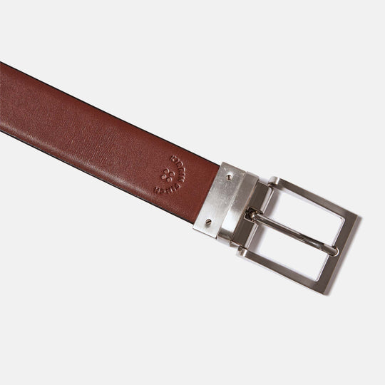 Reversible leather belt showing brown leather side, stamp embossed with Kirrin Finch logo