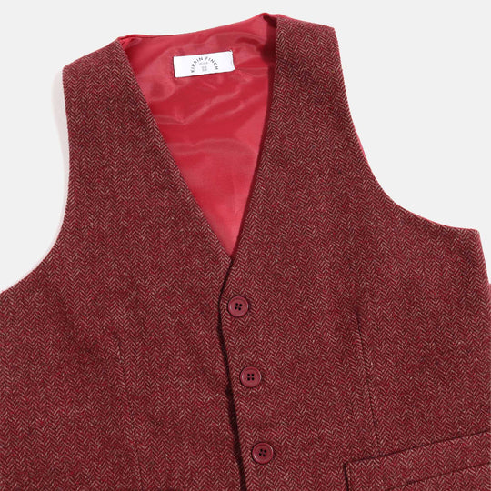 A close up shot of the burgundy tweed vest and Kirrin Finch label with signature four button logo