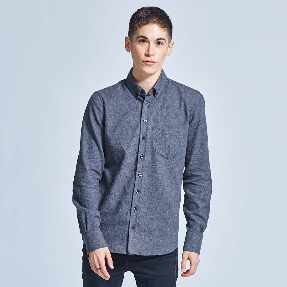 Androgynous model stoically wearing charcoal flannel on a neutral background