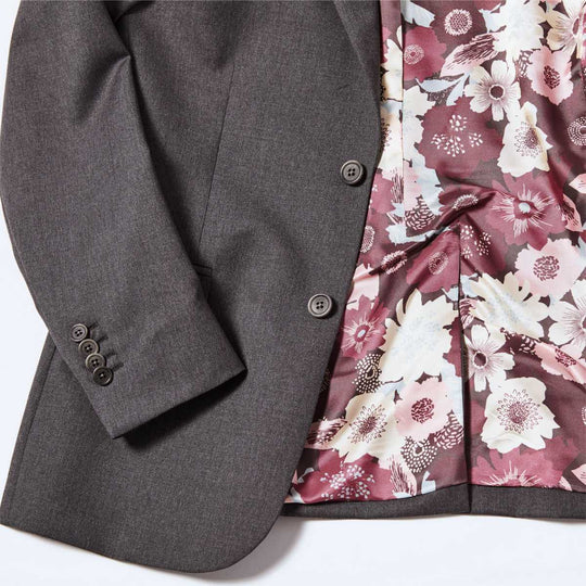 Georgie Charcoal Suit blazer detail shot of non0functional sleeve buttons and burgundy floral interior lining