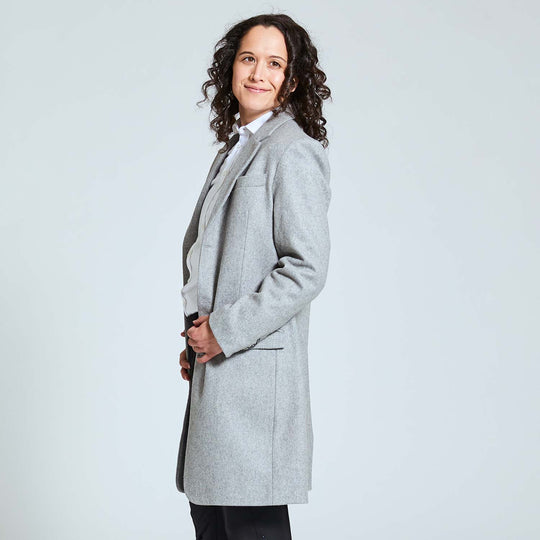 Model posing in profile stance wearing Kirrin Finch's Gray Overcoat