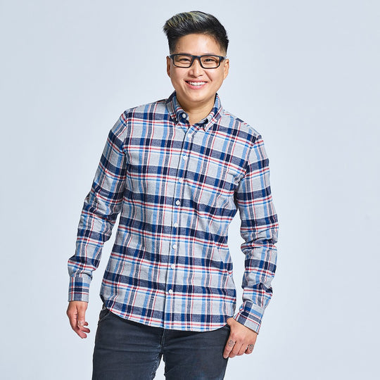 Model wearing a gray, red, and blue brushed plaid flannel shirt on neutral gray background