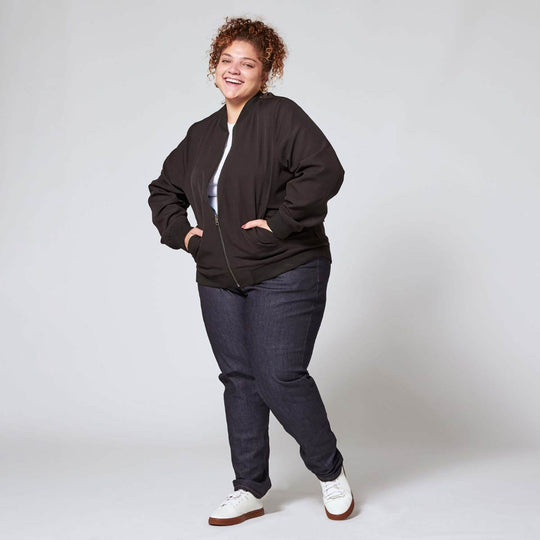 Plus size blue denim jeans on model paired with white sneakers
