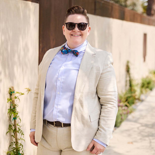 Model wearing a blue and white striped dress shirt with sand linen suit outside on a sunny LA Day
