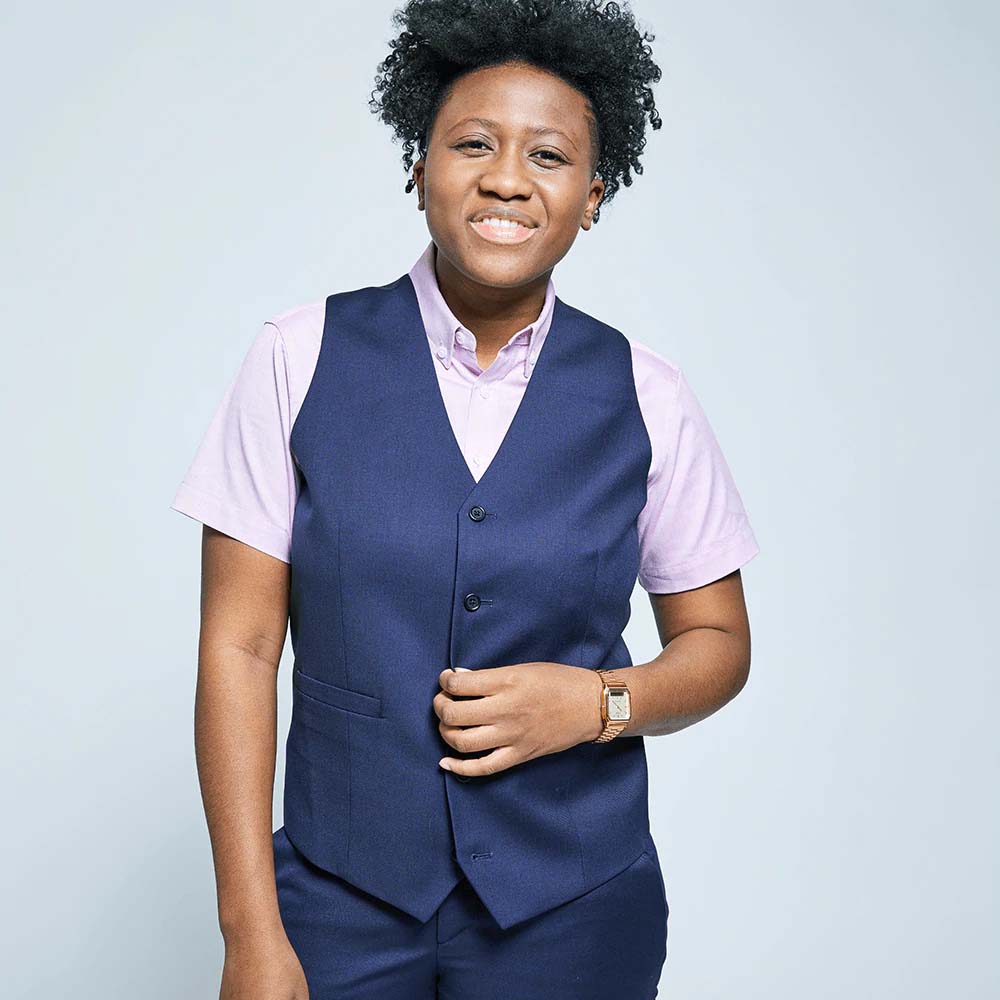 Smiling person modeling Georgie vest in navy blue on neutral background