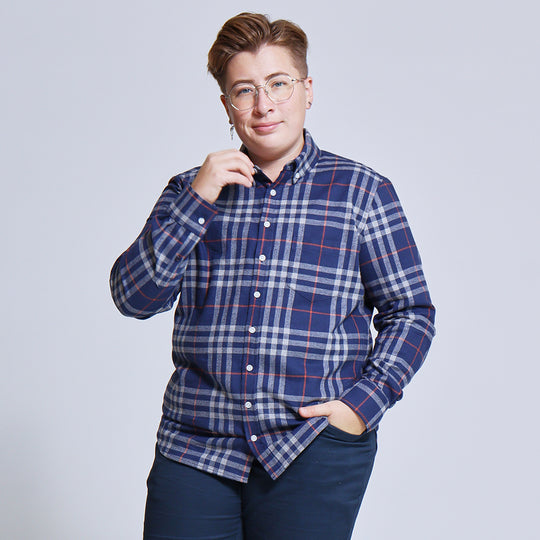 Person posing with one hand in pocket while wearing a navy and gray plaid flannel by Kirrin Finch