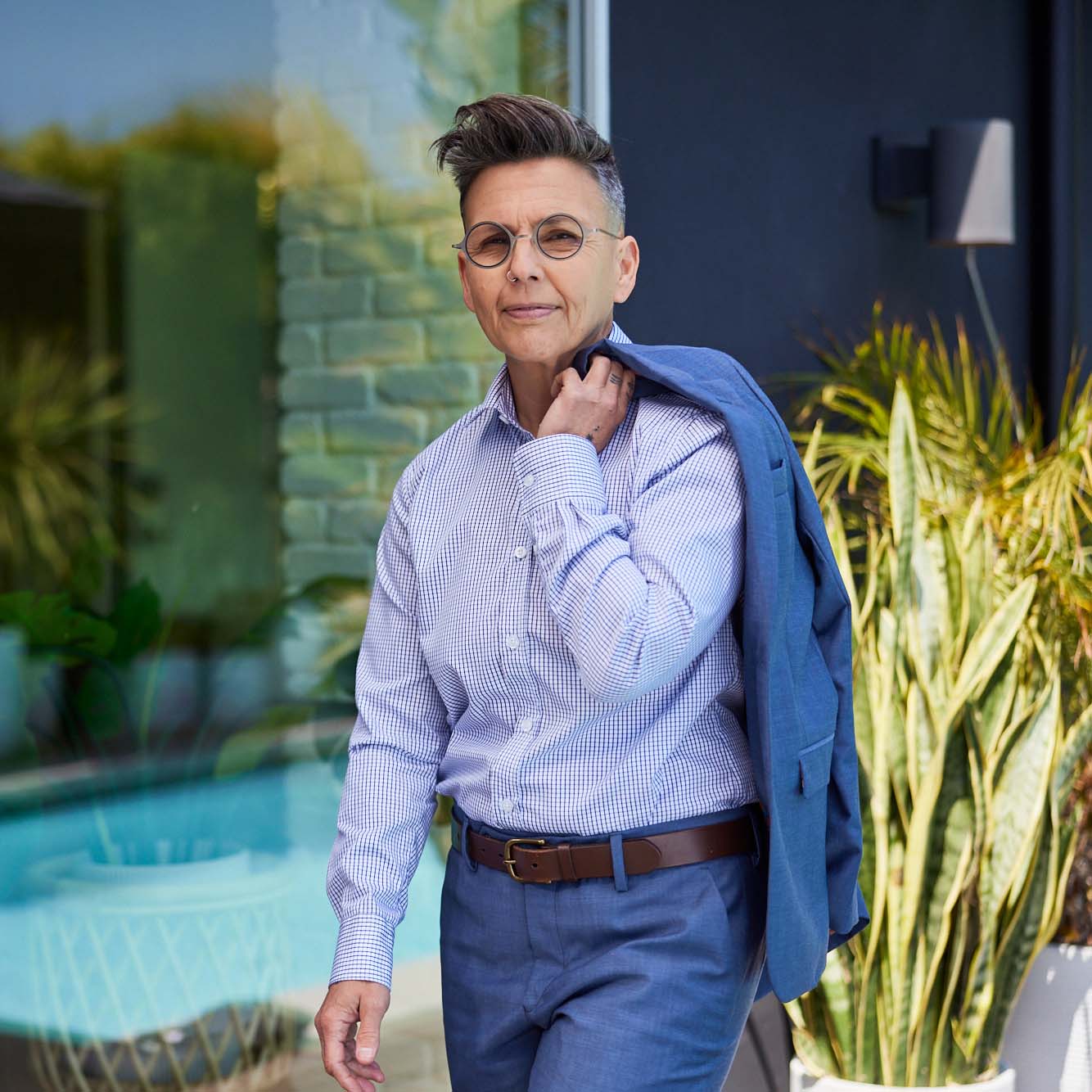 Model outside wearing grid shirt and slate blue suit, jacket slung over shoulder. Color: Navy Grid