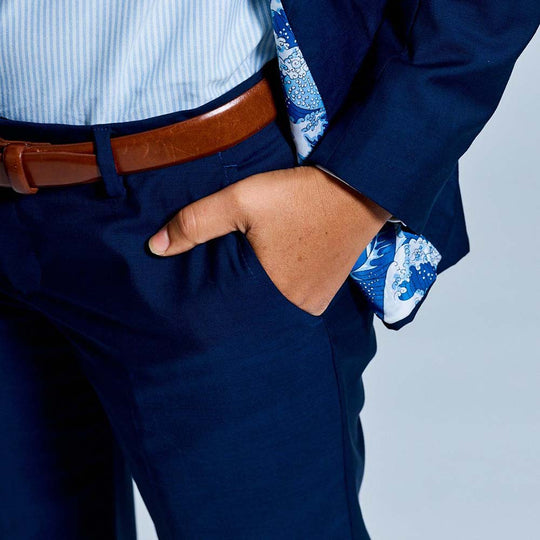 Detail shot of model's hand in right pocket of navy blue suit pants