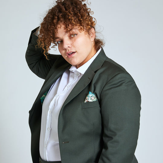Person modeling the Georgie Olive Blazer by Kirrin Finch. They are complimenting the blazer with the gold leaf pocket square that matches the blazer's interior lining