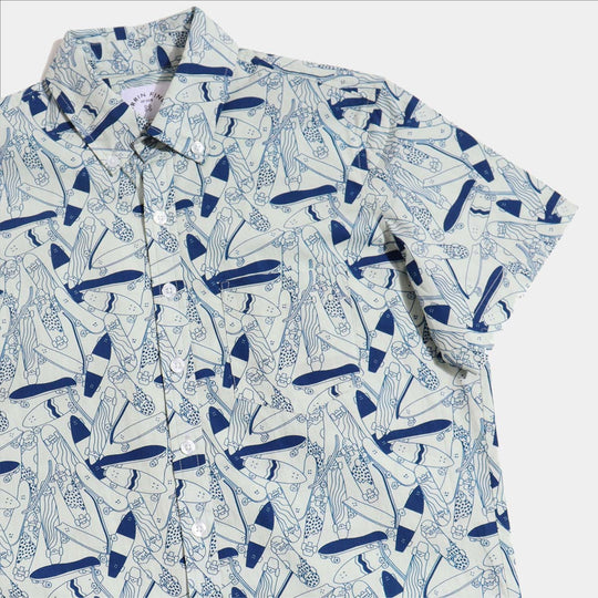 Light blue shirt with a skateboard print on neutral background