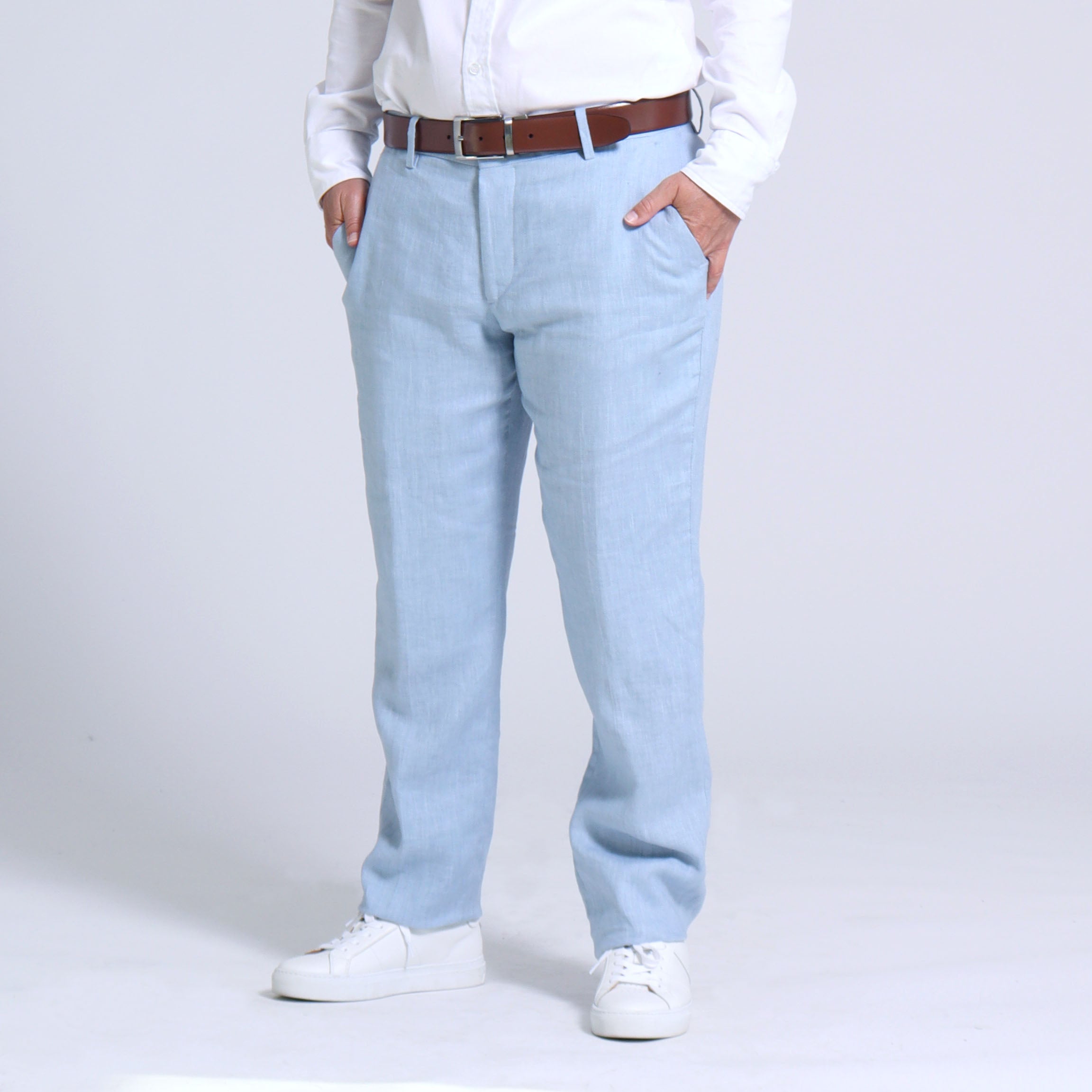 Premium Photo | A man stands in a dark room wearing a white shirt and light  blue pants.