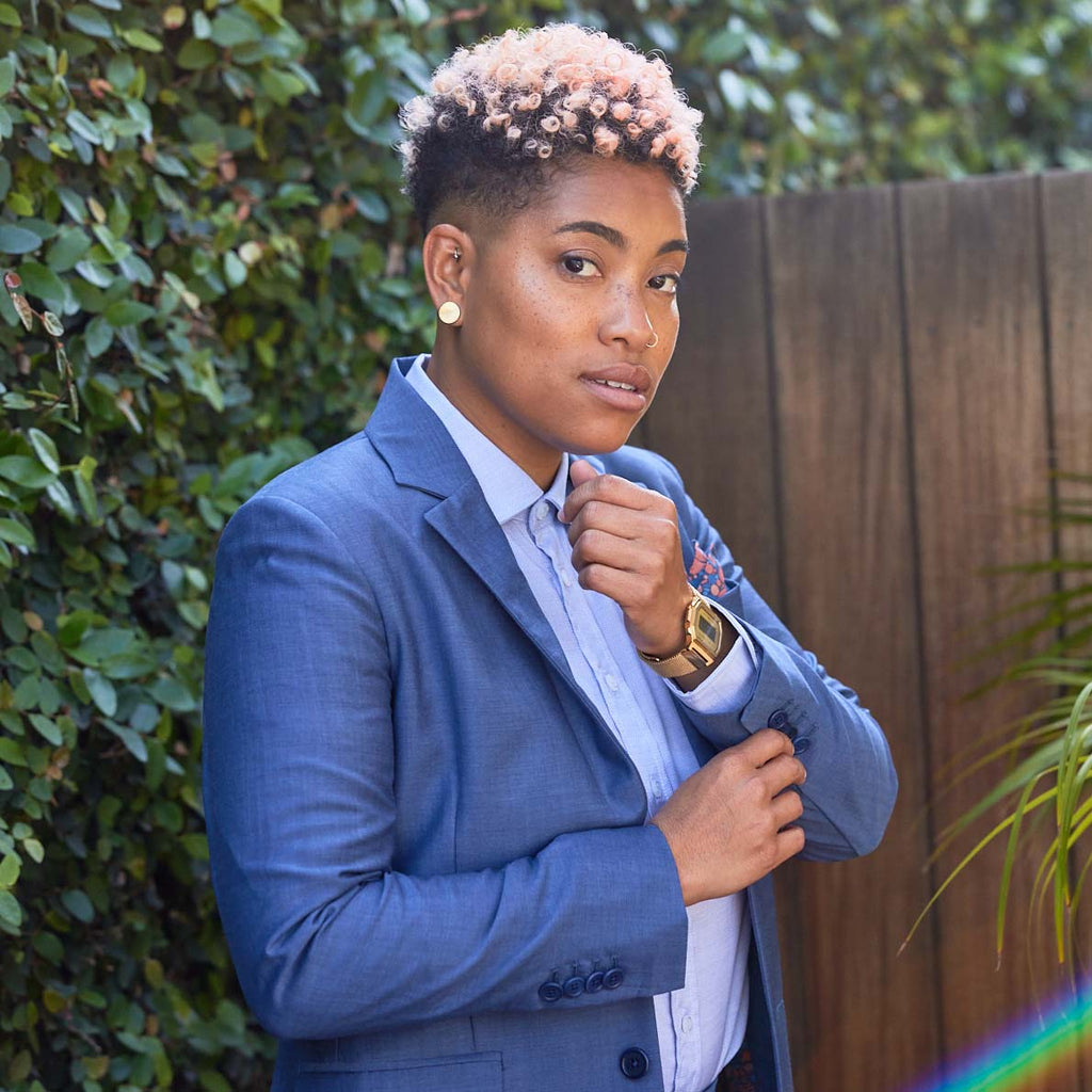 Model holding the 4 button cuff detail of the slate blazer