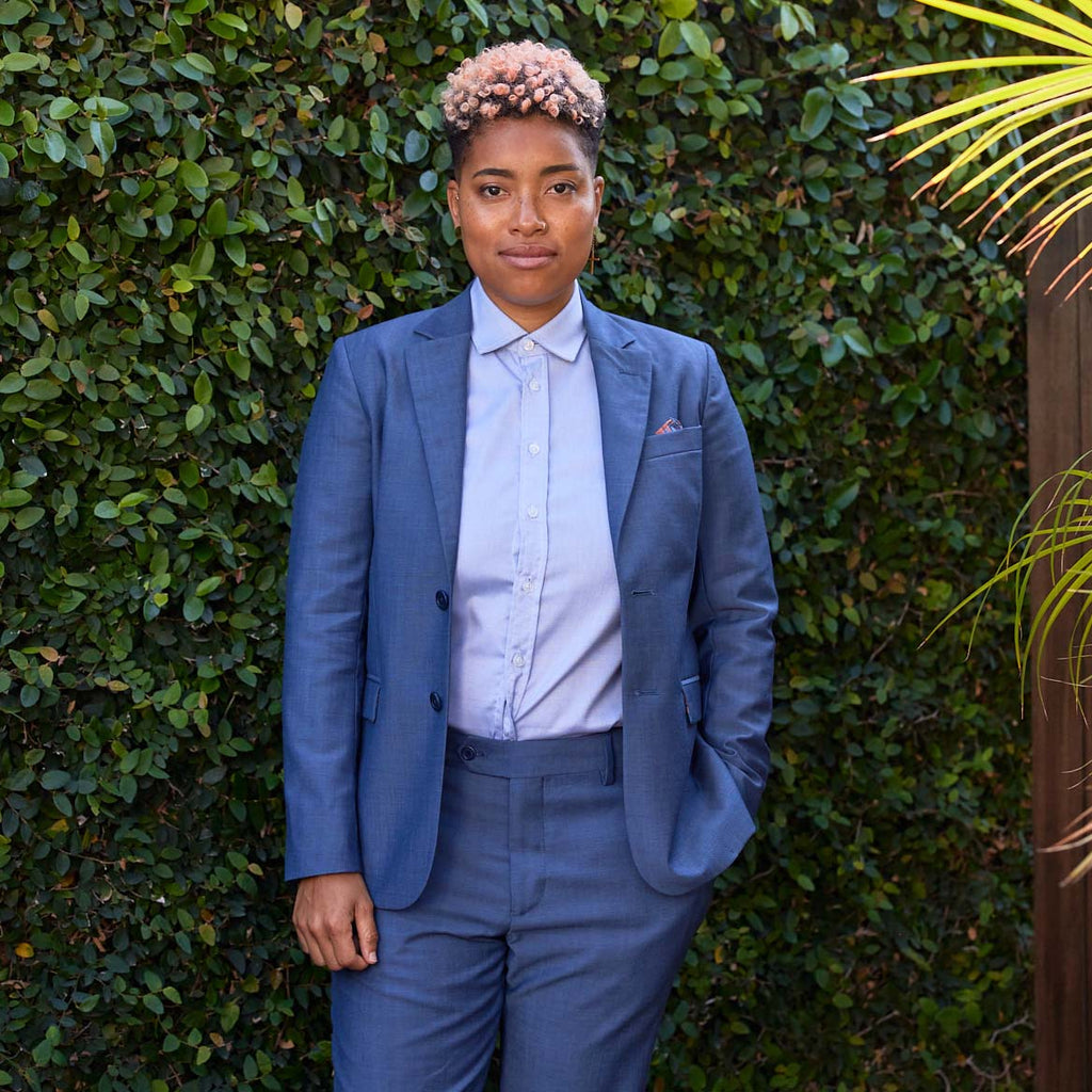 Model wearing androgynous slate blue blazer with lavender dress shirt.