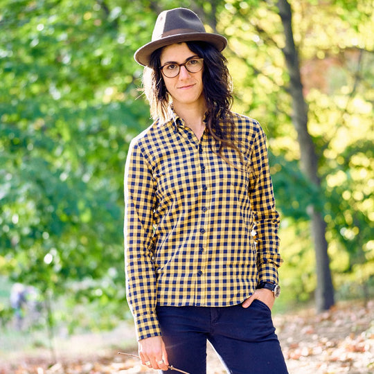 Model posing looking super cool in blue and yellow buffalo check shirt outdoors in the woods